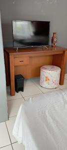 a flat screen tv sitting on top of a wooden table at Suíte para a Oktoberfest in Blumenau