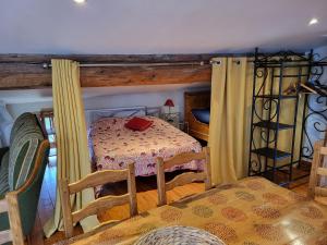 a bedroom with a bed with a table and chairs at Gite le grenier des maraichers in Albigny-sur-Saone +16 photos