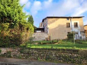 an old house with a fence in front of it at Gite le grenier des maraichers in Albigny-sur-Saone