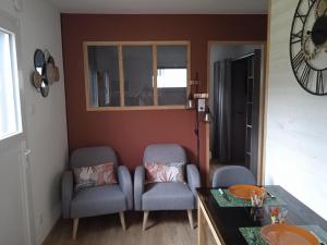 a living room with two chairs and a table at La Dépendance des Garennes in Saint-Étienne-au-Mont +6 photos