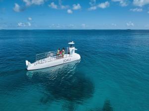 a group of people on a boat in the ocean at JOALI Maldives in Raa Atoll