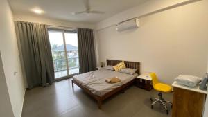 a bedroom with a bed and a desk and a window at Great Stays - WFH in Central Alleppey in Alleppey +7 photos