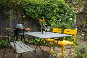 a table and chairs with a grill and a table with flowers at Spinner's Cottage in Burford