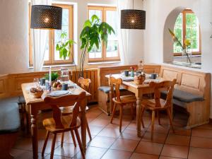 a dining room with two tables and chairs and windows at Haus Arlberg in Pettneu am Arlberg