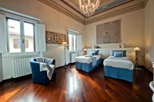 フィレンツェにあるScala Elegant Apartmentのベッドルーム1室(ベッド2台、シャンデリア付)
