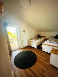 a room with two beds and a rug on the floor at Ferienwohnung Lory mit Schlossblick in Halblech