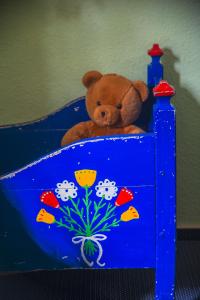 a brown teddy bear sitting in a blue bed at Hof Brockmann - Ferienhaus Spieker in Neuenkirchen