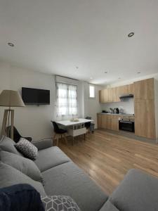 un salon avec un canapé et une table et une cuisine dans l'établissement Séjour en montagne, à La Cabanasse