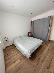une chambre avec un lit et un parquet dans l'établissement Séjour en montagne, à La Cabanasse