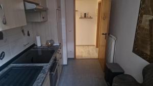 a small kitchen with a sink and a hallway at Gemütliches Apartment in Altendorf +1 photo