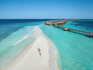 an aerial view of a beach with people walking on the sand at JOALI Maldives in Raa Atoll