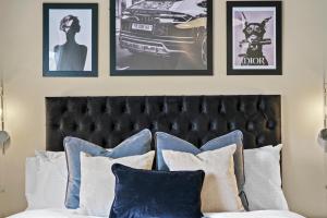 a bedroom with a bed with four pictures on the wall at 30 percent off! Exquisite Georgian Apartment with Reserved Parking in Wakefield