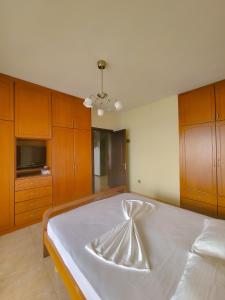 een slaapkamer met een groot bed met houten kasten bij Anja's Apartament in Sarandë