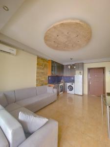 een woonkamer met een bank en een keuken bij Anja's Apartament in Sarandë