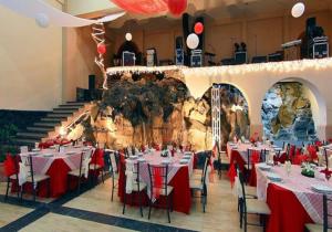 a dining room with tables and chairs and a stone wall at Hotel Misión Xalapa in Xalapa