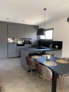 a kitchen with a table and chairs in a room at Maison Jacuzzi in Thonon-les-Bains
