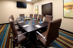 una sala de conferencias con una mesa larga y sillas de cuero en Hawthorn Suites by Wyndham Bridgeport, en Bridgeport