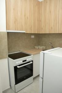 a kitchen with a stove and a white refrigerator at M apartman Kragujevac in Kragujevac