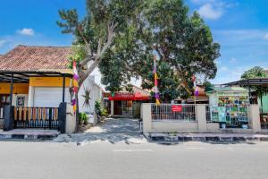 a street with a tree in front of a building at Hotel O Homestay Alqid Syariah in Yogyakarta