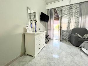 a living room with a white dresser and a television at L’angolo rosa in Carosino