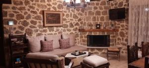 a living room with a couch and a fireplace at Νόστος in Ano Trikala