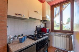 a kitchen with a stove top oven next to a window at La Casa In Campagna 800m from lake - Happy Rentals in Leggiuno