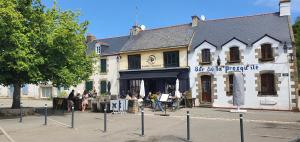 Un bâtiment avec des personnes assises à l'extérieur dans l'établissement St Gildas de Rhuys - Maison 10 personnes avec 5 chambres, 900 m plage et 500 m centre bourg, à Saint-Gildas-de-Rhuys