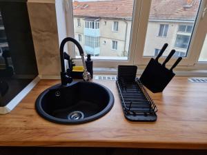 a kitchen counter with a black sink and a window at Modern Studio 2 in Onești