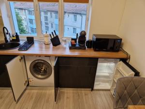 a desk with a microwave and a washing machine at Modern Studio 2 in Onești +10 photos