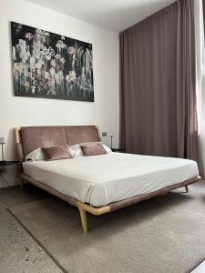 a bedroom with a large bed with a large painting on the wall at Lisetta Gardens Boutique & Suites in Cisternino