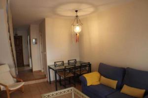 Una sala de estar con un sofá azul y una mesa. en Islantilla Beach Golf, en Islantilla