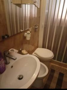 a bathroom with a white sink and a toilet at Villa della Concordia in Plaia Grande +11 photos