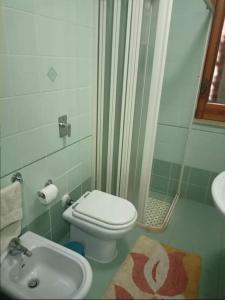a bathroom with a toilet and a shower and a sink at Villa della Concordia in Plaia Grande