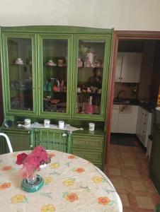 a green cabinet with a table in a kitchen at Villa della Concordia in Plaia Grande
