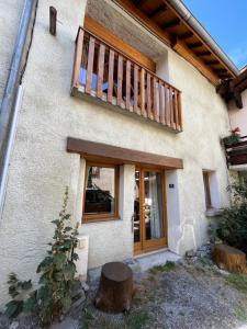 a house with a wooden balcony on top of it at The Stable House Bourg d’Oisans -bike/hike/ski in Le Bourg-dʼOisans
