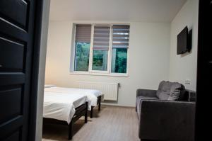 ein Zimmer mit zwei Betten und einer Couch und einem Fenster in der Unterkunft D&T Hotel in Ilʼtsya Dolishna + 79 Fotos