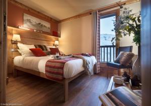a bedroom with a large bed and a balcony at Le Hameau de la Sapinière in Les Menuires