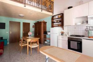 a kitchen with white cabinets and a table with chairs at Villa Shanti Yoga & Meditation in Marciana