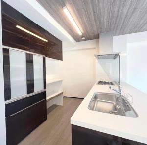 una cucina con lavandino e armadi neri di MA house 701 ad Osaka Altre 41 foto