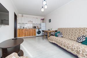 a living room with a couch and a table at Уютная Евродвушка рядом с Центральной Мечетью in Pavlodar