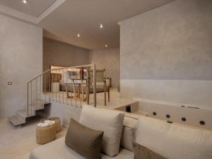 a living room with a couch and a bed at Hestia Boutique - Renovated Rooms Just Steps from the Beach in Agia Marina Nea Kydonias