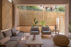 a living room with a couch and chairs and a table at Hestia Boutique - Renovated Rooms Just Steps from the Beach in Agia Marina Nea Kydonias