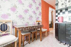a kitchen with a table and chairs in a room at Три комнаты в Центре. in Pavlodar