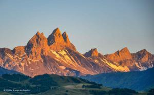 un grupo de montañas con el sol brillando sobre ellas en La Grange des Aiguilles, en Albiez-le-Jeune