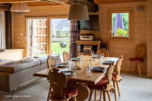 Un comedor con mesa y sillas de madera. en La Grange des Aiguilles, en Albiez-le-Jeune