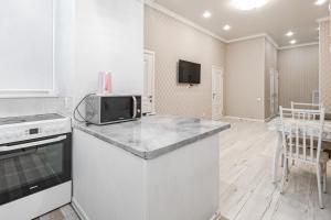 a kitchen with a counter top and a microwave at Трех комнатные апартаменты в новом доме рядом с Батырмол in Pavlodar +9 photos