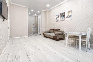 a living room with a couch and a table at Трех комнатные апартаменты в новом доме рядом с Батырмол in Pavlodar