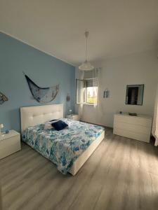 a bedroom with a bed and a blue wall at Eremia in Giardini Naxos