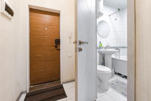 ein Badezimmer mit Toilette und Holztür in der Unterkunft Трехкомнатная квартира рядом с ЖД вокзалом in Pawlodar