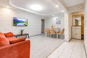 ein Wohnzimmer mit Sofa und Tisch in der Unterkunft Трехкомнатная квартира рядом с ЖД вокзалом in Pawlodar